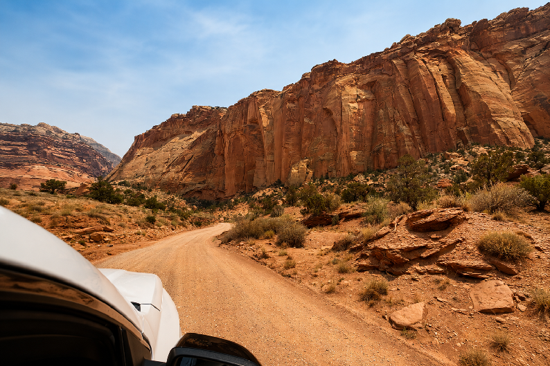 Driving the Capitol Gorge Road through towering sandstone cliffs in Capitol Reef National Park, Utah.